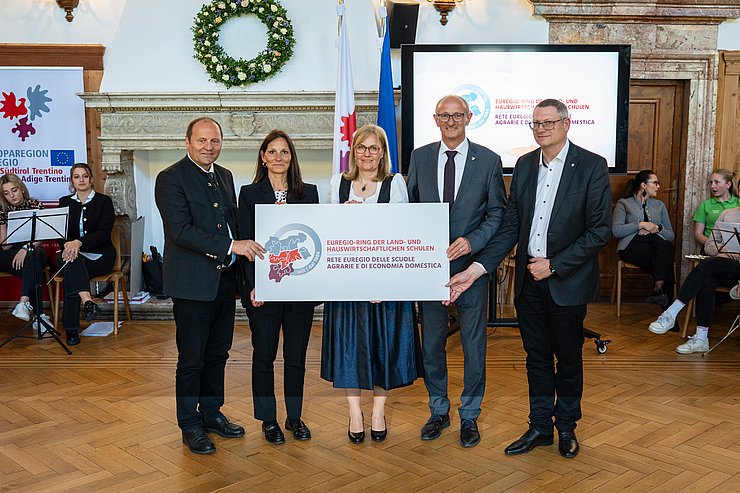 © Land Tirol/Fitsch Personen stehen nebeneinander, halten Schild