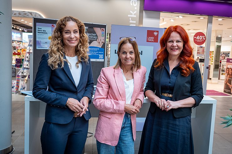 © Land Tirol/Neuner Drei Frauen vor einem Informationsstand.