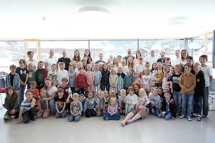 Gruppenfoto von LRin Hagele, den Bürgermeistern der Gemeinden St. Sigmund im Sellrain sowie Gries im Sellrain, dem Abt des Stiftes Wilten und den LehrerInnen sowie SchülerInnen der Volksschule Gries im Sellrain.