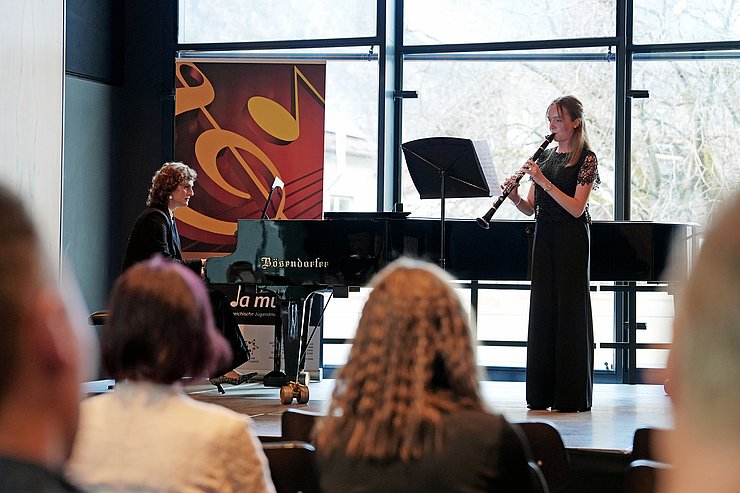 © Land Tirol/Neuner Ein Mädchen spielt auf einer Bühne Klarinette.