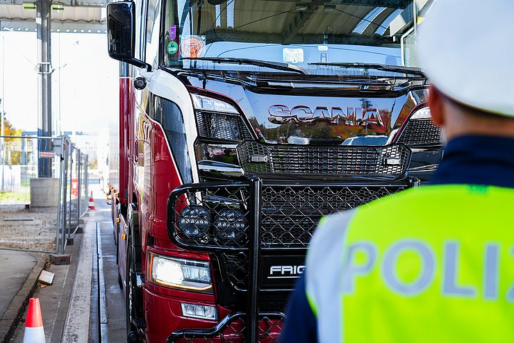 Lkw, im Vordergrund ein Polizist
