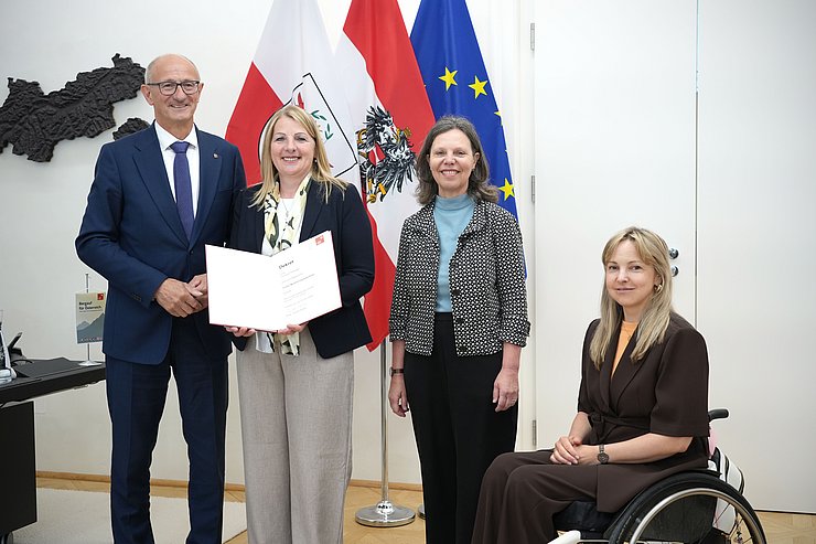 © Land Tirol/Trenker Personen stehen nebeneinander, Hörtnagel hält Dekret