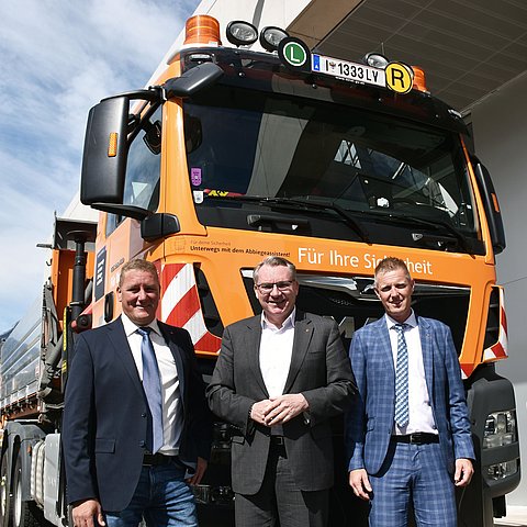 Gruppenfoto vor LKW; auf der Front Aufkleber des Abbiegeassistenten