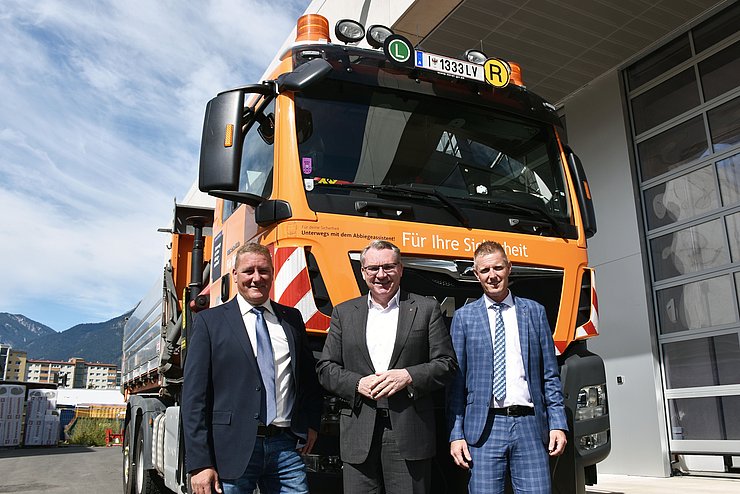 Gruppenfoto vor LKW; auf der Front Aufkleber des Abbiegeassistenten