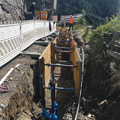 Zu sehen sind neu verlegte Rohre in einem Graben: Der Pfundser Ortsteil Greit wird an das Kanalnetz angeschlossen, die Wasserversorgung wird teils erneuert.