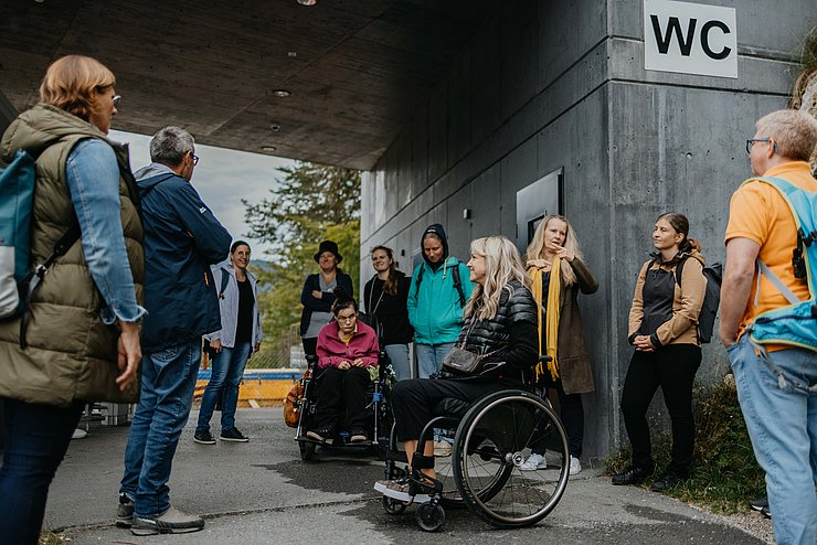 Gruppe in Halbkreis vor Zubau Toilette