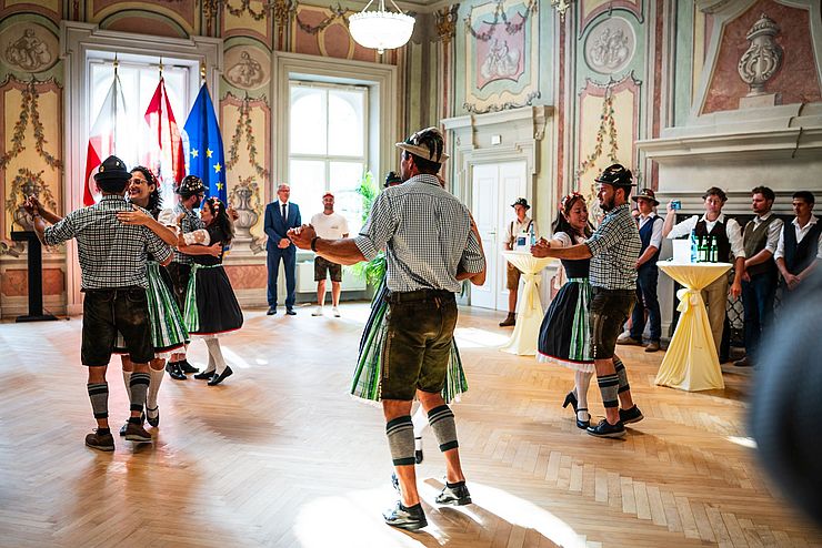 Tänzerinnen und Tänzer der Gemeinde Pozuzo tanzen in Tiroler Tracht im Parissaal des Landhauses