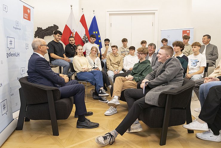 LH Mattle sitzt vor der Schulklasse und beantwortet die Fragen der SchülerInnen.