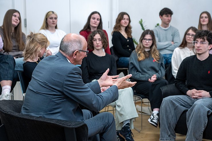 SchülerInnen sitzen um LH und hören gespannt zu.
