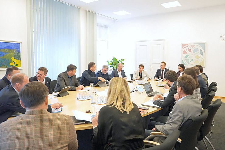 Tisch mit Menschen darum sitzend