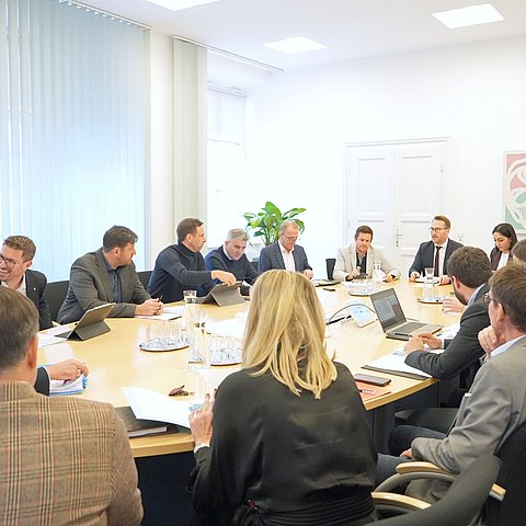 Tisch mit Menschen darum sitzend