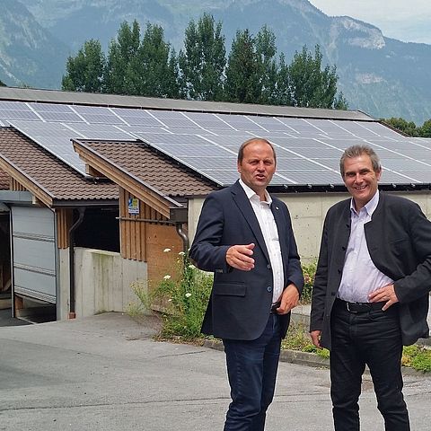 LHStv Geisler und Direktor Norz stehen vor der im Jahre 2015 errichteten PV-Anlage auf dem Dach des Kälberstalls.