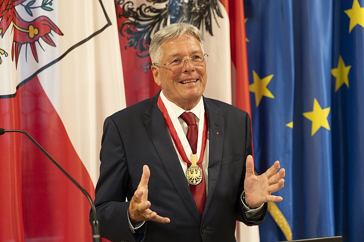 © Land Tirol/Sedlak Ein grauhaariger Mann gestikuliert mit beiden Händen.