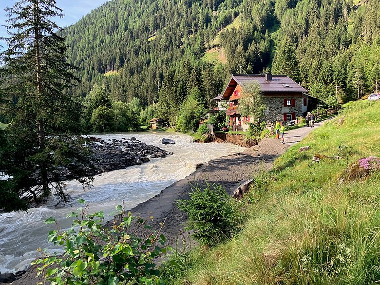 Fluss mit Hochwasser; zerstörte Straße 