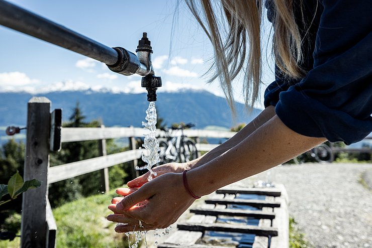 Hände unter fließendem Wasser von Brunnen