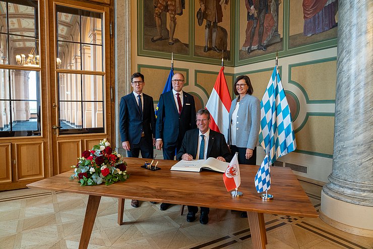 © Tiroler Landtag/Oswald Zu Beginn des Antrittsbesuch trug sich LTP Jakob Wolf (sitzend) im Beisein von (v.re.) LTPin Isle Aigner, VLTP Alexander Hold und LTD Andreas Kamml ins Gästebuch des Bayerischen Landtags ein.