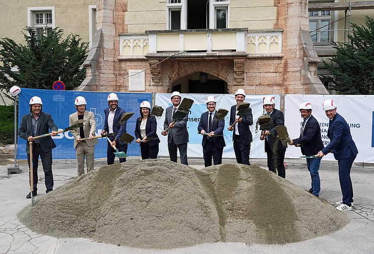 © Land Tirol/Pölzl Menschen mit Helmen und Schaufeln hinter Sandhaufen