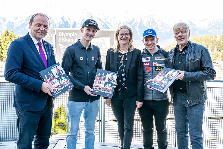 Gruppenfoto im Freien; Personen halten Sportjahrbuch in Händen