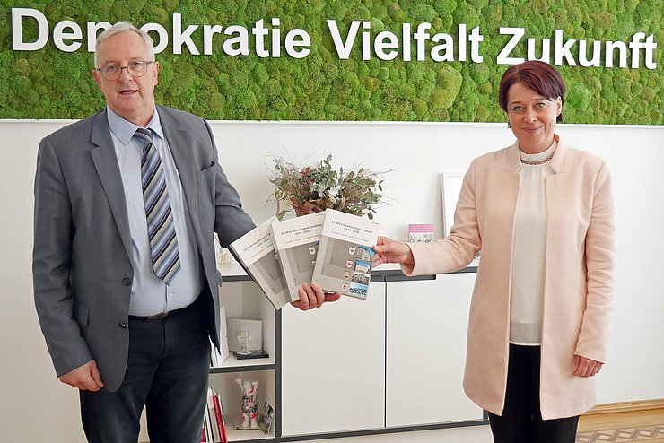 Josef Siegele übergibt LTPin Sonja Ledl-Rossmann das dreibändige Werk.