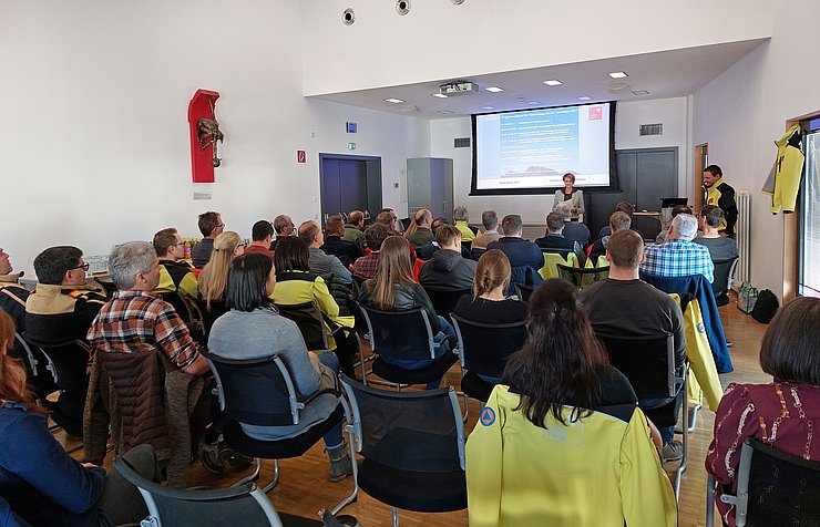 Die rund 50 Teilnehmenden sitzen im Saal und werden von der Bezirkshauptfrau begrüßt