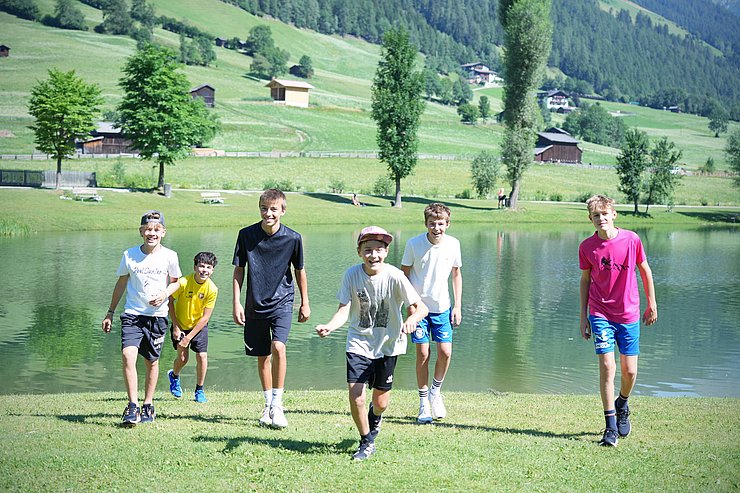 © Land Tirol/Schallhart Burschen laufen der Kamera entgegen, im Hintergrund ein See