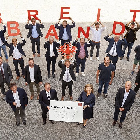 Landeshauptmann Günther Platter (vorne, 3. von links), Landesrätin Patrizia Zoller-Frischauf (vorne, 4. von links), Gemeindeverbandspräsident Ernst Schöpf (vorne, 2. von links) und Arno Abler, Geschäftsführer der landeseigenen Breitbandserviceagentur (vorne, 1. von links) mit den Vertretern von 13 Internet-Betreibergesellschaften bei der Unterzeichnung des „Glasfaserpakts für Tirol“. 