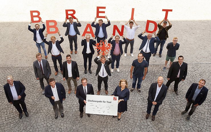 Landeshauptmann Günther Platter (vorne, 3. von links), Landesrätin Patrizia Zoller-Frischauf (vorne, 4. von links), Gemeindeverbandspräsident Ernst Schöpf (vorne, 2. von links) und Arno Abler, Geschäftsführer der landeseigenen Breitbandserviceagentur (vorne, 1. von links) mit den Vertretern von 13 Internet-Betreibergesellschaften bei der Unterzeichnung des „Glasfaserpakts für Tirol“. 