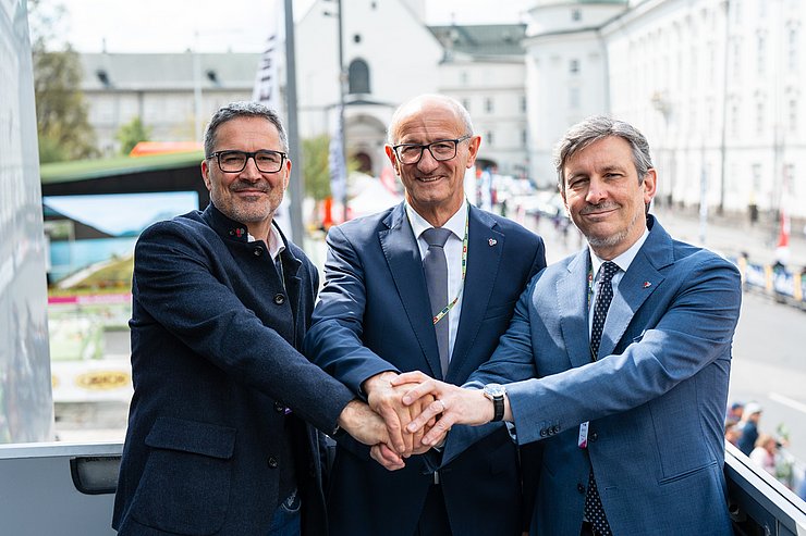 Personen stehen nebeneinander, legen Hände übereinander