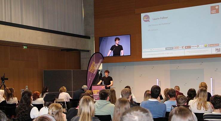 Jugendlicher spricht vor Publikum