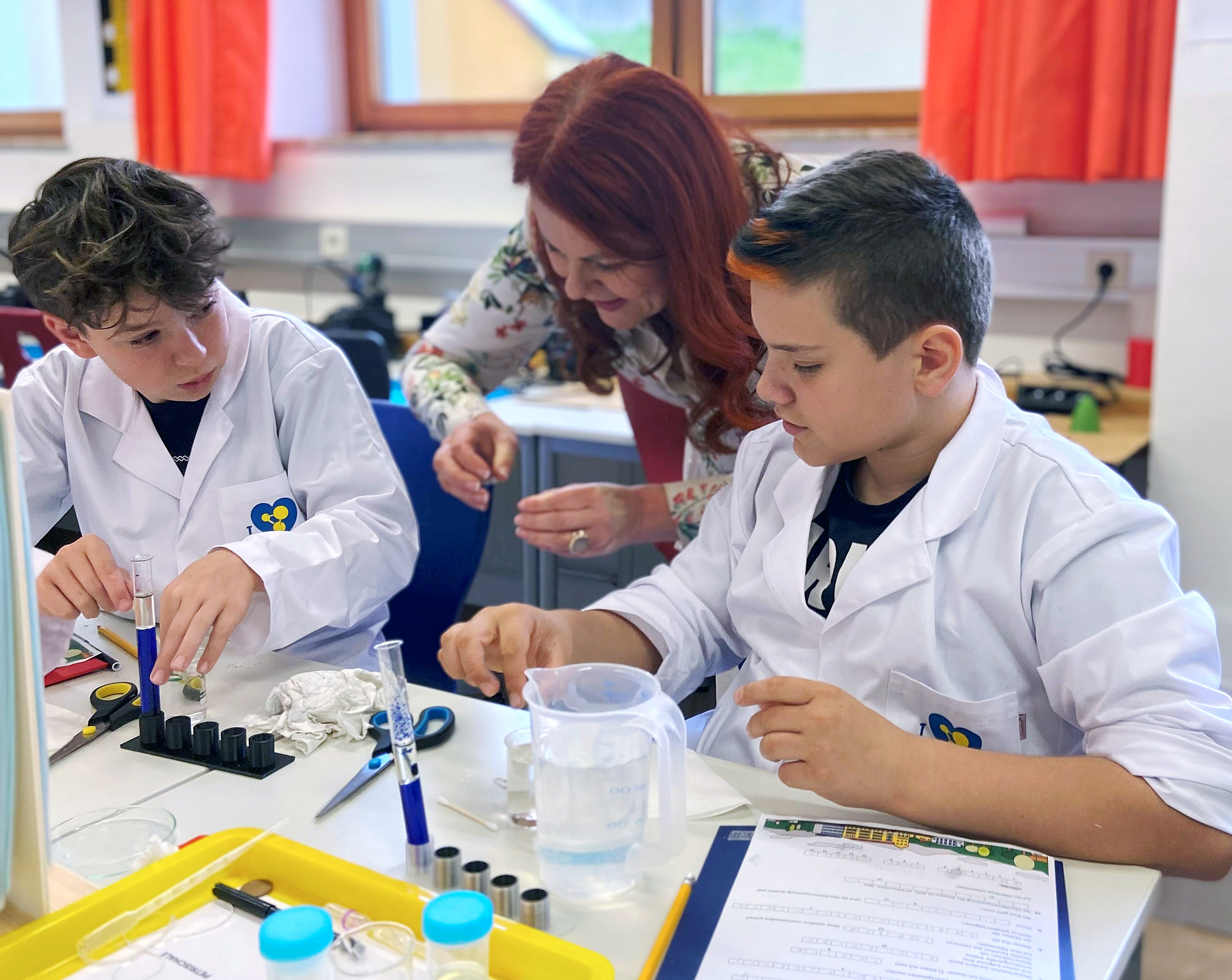 LRin Hagele mit Schülern vor Laborgeräten