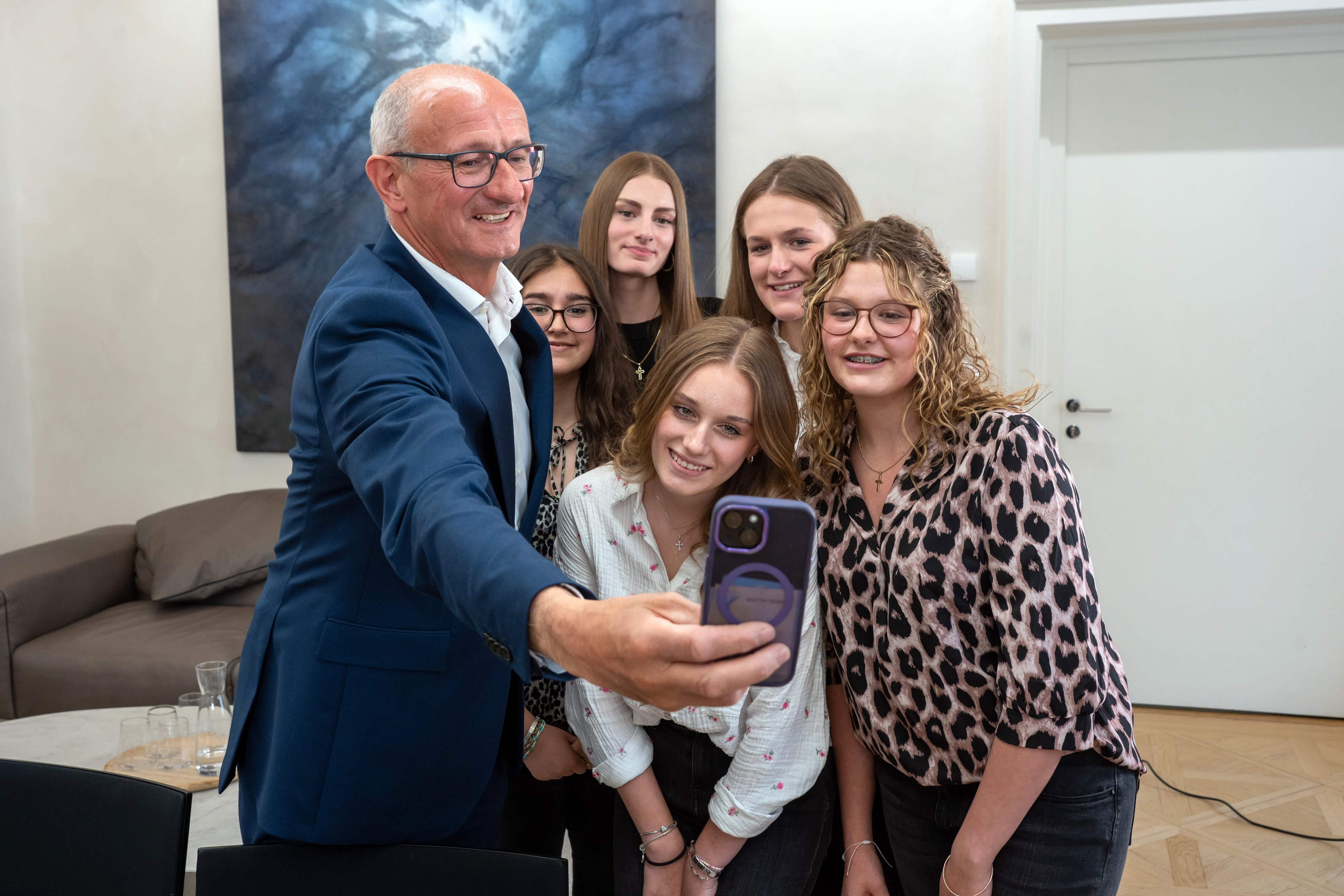 Mann macht Selfie mit 5 Schülerinnen.